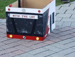 Box that looks like the front of an OC Transpo bus with "Fix The LRT" written on it